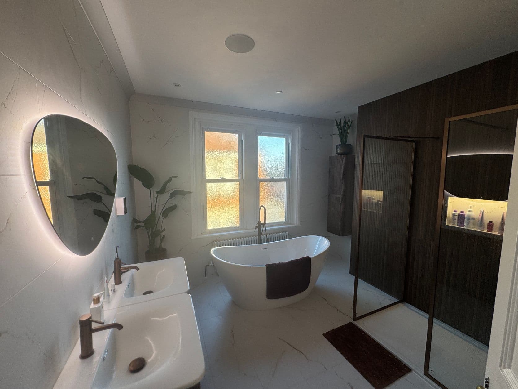Premium Leeds bathroom installation with freestanding bath, twin basins, illuminated mirror and walk-in shower